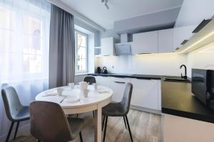 a kitchen with a white table and chairs in a room at Baltic Gdańsk OLD TOWN by St Mary s Church in Gdańsk