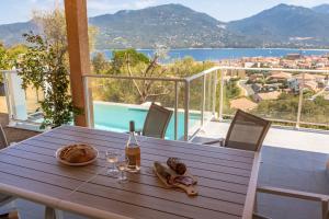einen Holztisch mit einem Teller Essen auf dem Balkon in der Unterkunft Casa campa lumba in Propriano