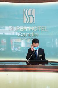 un hombre con una máscara hablando por celular en Super Hotel Candle, en Hanói
