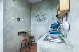 uma cozinha com um lavatório e dois bancos em The Backyard Villas em Tabanan