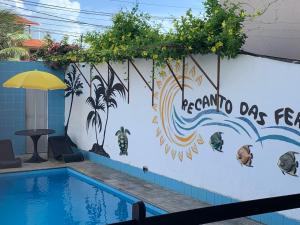 a swimming pool with a mural on a wall at Pousada Recanto das Férias in Fortaleza