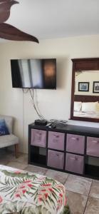 a room with a dresser with a tv on the wall at Kihei Kai Nani Resort in Kihei