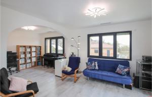 sala de estar con sofá azul y piano en Nice Home In St Marcellin With House A Panoramic View, 
