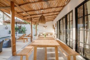 ein Wohnzimmer mit einem Tisch und Bänken in der Unterkunft Villa Ruta I - Sumptuous 2BR Private Luxury Villa Walking Distance to Nyanyi Beach in Tanah Lot