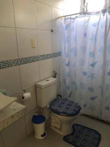 a bathroom with a toilet and a shower curtain at Paraíso dos Oliveira in São José da Coroa Grande +18 photos