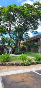un bâtiment avec des arbres et des plantes en face d'une rue dans l'établissement Kihei Kai Nani Resort, à Kihei
