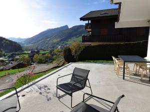 a patio with chairs and a table with a view at Appartement Le Grand-Bornand, 3 pièces, 5 personnes - FR-1-458-174 in Le Grand-Bornand