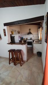 a kitchen with a counter and two stools in it at Casa tafi in Tafí del Valle