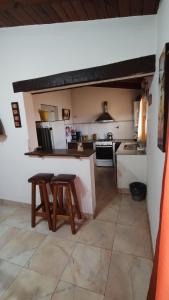 a kitchen with a counter and two stools in it at Casa tafi in Tafí del Valle +18 photos
