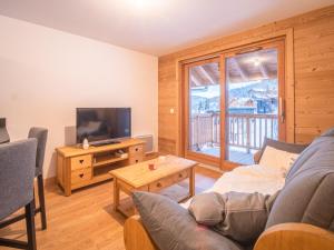 a living room with a couch and a television at Appartement Valmorel, 2 pièces, 4 personnes - FR-1-356-412 in Valmorel