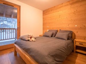 um urso de peluche sentado numa cama num quarto em Appartement Valmorel, 2 pièces, 4 personnes - FR-1-356-412 em Valmorel
