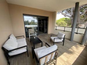 un salon avec des meubles blancs et de grandes fenêtres dans l'établissement Beau T3 tout confort à 200m de la plage avec clim, terrasse et garage, Cavalaire-sur-Mer - FR-1-100-314, à Cavalaire-sur-Mer