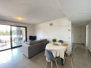 un salon avec une table et un canapé dans l'établissement Beau T3 tout confort à 200m de la plage avec clim, terrasse et garage, Cavalaire-sur-Mer - FR-1-100-314, à Cavalaire-sur-Mer