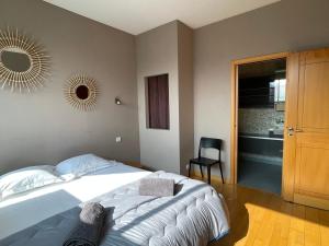 ein Schlafzimmer mit einem Bett, einem Stuhl und einem Spiegel in der Unterkunft Appartement Aix-les-Bains, 5 pièces, 6 personnes - FR-1-555-91 in Aix-les-Bains