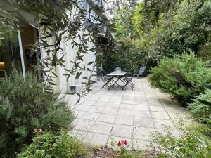eine Terrasse mit einem Tisch und Stühlen im Garten in der Unterkunft Appartement Aix-les-Bains, 5 pièces, 6 personnes - FR-1-555-91 in Aix-les-Bains