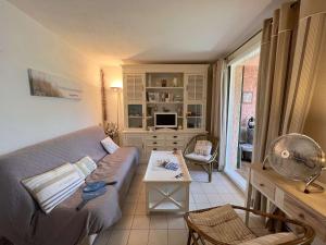 ein Wohnzimmer mit einem Sofa und einem Tisch in der Unterkunft Appartement Saint-Aygulf, 2 pièces, 4 personnes - FR-1-226A-161 in Fréjus