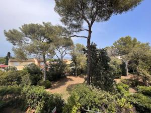 einen Garten mit Bäumen und Sträuchern vor einem Haus in der Unterkunft Appartement Saint-Aygulf, 2 pièces, 4 personnes - FR-1-226A-161 in Fréjus