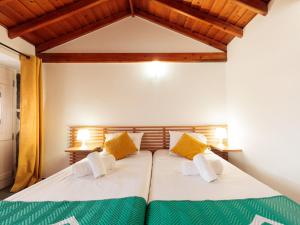 1 dormitorio con 1 cama con sábanas amarillas y verdes en holiday home, Praínha de Baixo, en Prainha de Baixo
