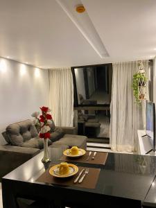 un soggiorno con divano e tavolo di Barra Home Stay - Beira mar - 2 QUARTOS a Recife