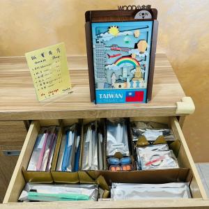 a wooden drawer with a book and a note at Wind Sea Hill Inn in Hengchun South Gate