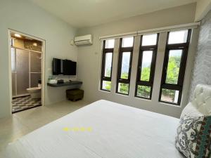 靚民宿-有車位-需付訂金 في جيان: غرفة نوم بسرير ابيض كبير ونوافذ