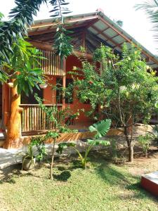 une maison avec une véranda et des arbres devant elle dans l'établissement La Perla Bentota, à Bentota