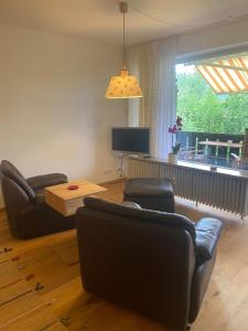 a living room with two leather chairs and a television at Appartement Raineck in Mittenwald