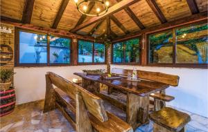 een eetkamer met een houten tafel en banken bij Pet Friendly Home In Brstanovo With Kitchen in Brštanovo