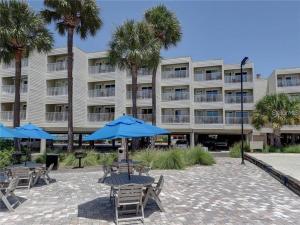 um hotel com cadeiras e guarda-sóis em frente a um edifício em The Kondo Tiki em Tampa