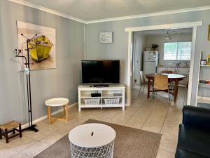 a living room with a flat screen tv and a table at Wrentree - Pet Friendly Inside 26B Laurel Tce in Robe
