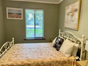 a bedroom with a white bed with a window at Wrentree - Pet Friendly Inside 26B Laurel Tce in Robe