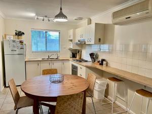 a kitchen with a wooden table and a table and chairs at Wrentree - Pet Friendly Inside 26B Laurel Tce in Robe