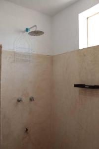 een badkamer met een douche met een douchekop bij Qué Chula casa. in Izamal