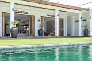 a house with a swimming pool next to a house at RUMAH WAYAN ULUWATU in Uluwatu