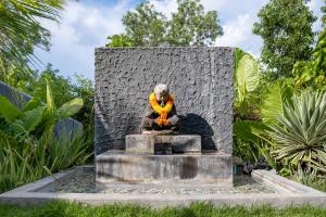 a statue of a dog sitting in a fountain at RUMAH WAYAN ULUWATU in Uluwatu