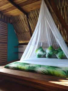 Cama en habitación con mosquitera en Playa Kai Glamping, en La Punta de los Remedios