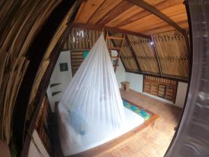 an overhead view of a room with a bed with a net at Playa Kai Glamping in La Punta de los Remedios