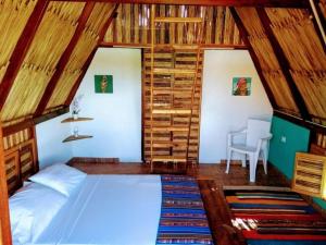 ein Schlafzimmer mit einem Bett in einem Zimmer mit Holzwänden in der Unterkunft Playa Kai Glamping in La Punta de los Remedios