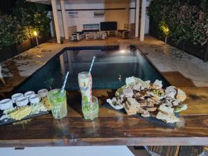 una mesa con bebidas y comida junto a la piscina en Pension ANAPA LODGE - MOOREA en Vaianae
