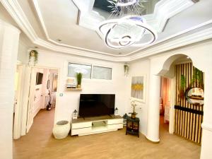 a living room with a tv and a ceiling at Appartement LOUIS XIV avec HAMMAM SAUNA JACCUZI PRIVATISÉ TOTALEMENT GRATUIT SANS SUPPLÉMENT ! in Al Hoceïma