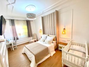 a white bedroom with a bed and a desk at Appartement LOUIS XIV avec HAMMAM SAUNA JACCUZI PRIVATISÉ TOTALEMENT GRATUIT SANS SUPPLÉMENT ! in Al Hoceïma