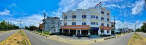 a large white building on the side of a road at Hotel Peaceland Lumbini in Lumbini