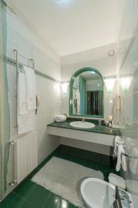 a white bathroom with a sink and a mirror at Hotel Villa Giulia in Tortona