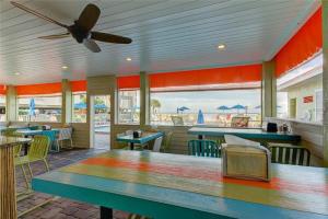 a restaurant with tables and chairs with a view of the beach at The Kondo Tiki in Tampa