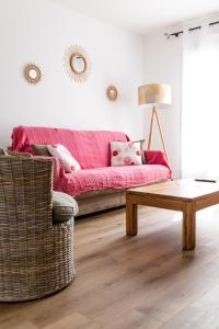 un soggiorno con divano rosa e tavolino da caffè di Maison de Larros, au calme idéalement placée a Gujan-Mestras