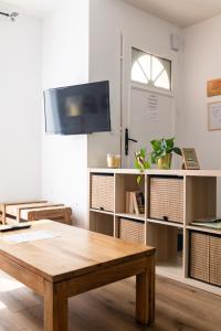 un soggiorno con tavolo in legno e TV di Maison de Larros, au calme idéalement placée a Gujan-Mestras