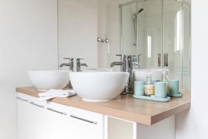 un bancone del bagno con due lavandini e due specchi di Maison de Larros, au calme idéalement placée a Gujan-Mestras Altre 27 foto