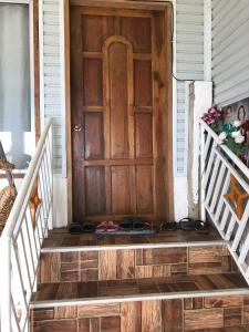 una puerta de madera en una casa con zapatos en el porche en Ady ching's Place, 