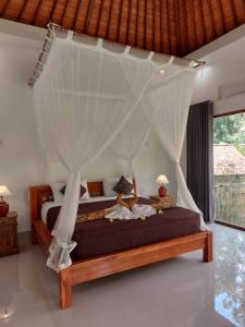 a bedroom with a bed with a canopy at Pondok Kukuh villa Sidemen in Sidemen