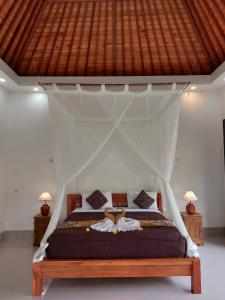 a bedroom with a bed with a canopy at Pondok Kukuh villa Sidemen in Sidemen